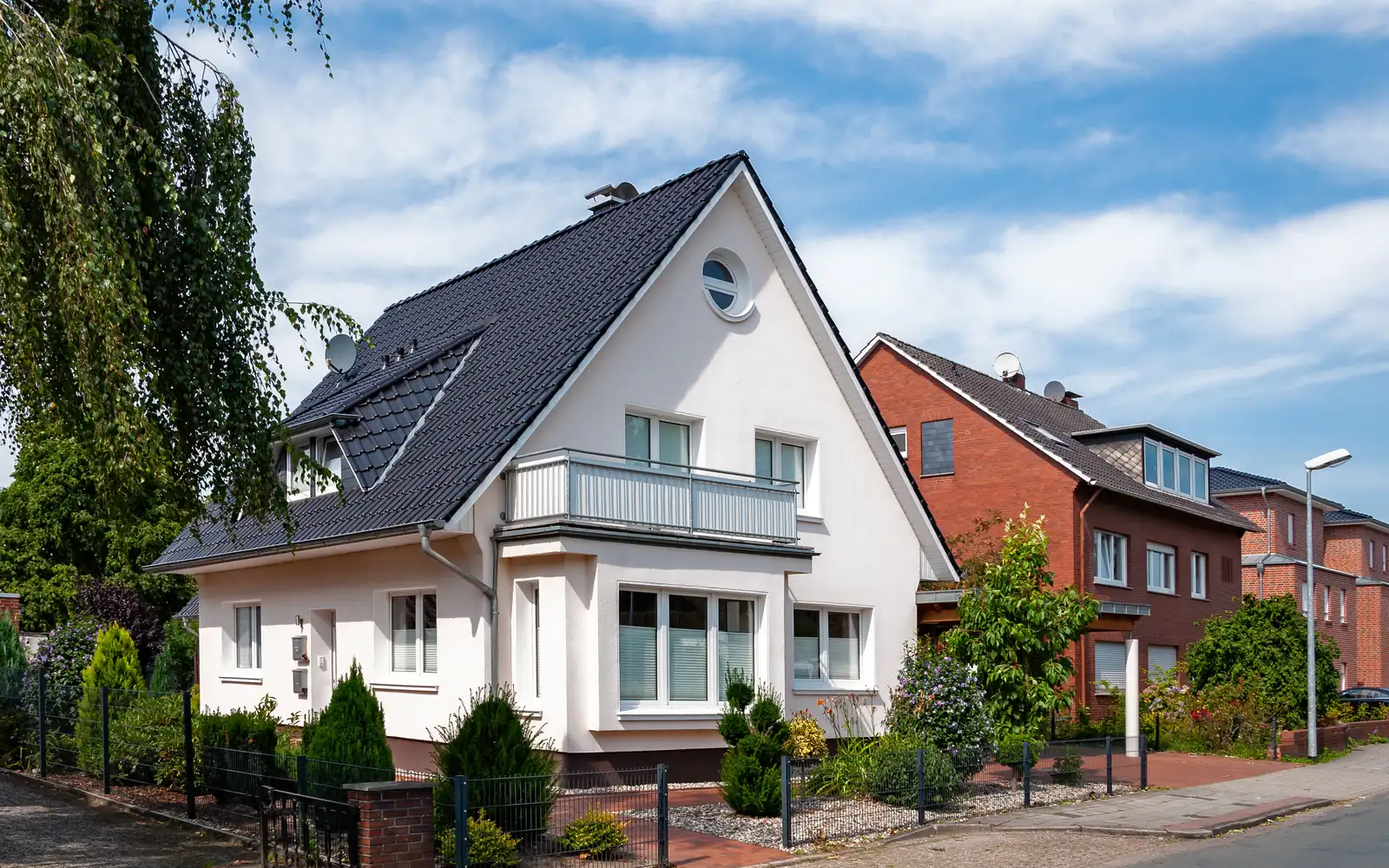 Einfamilienhaus mit verputzter Fassade von der Straßenseite